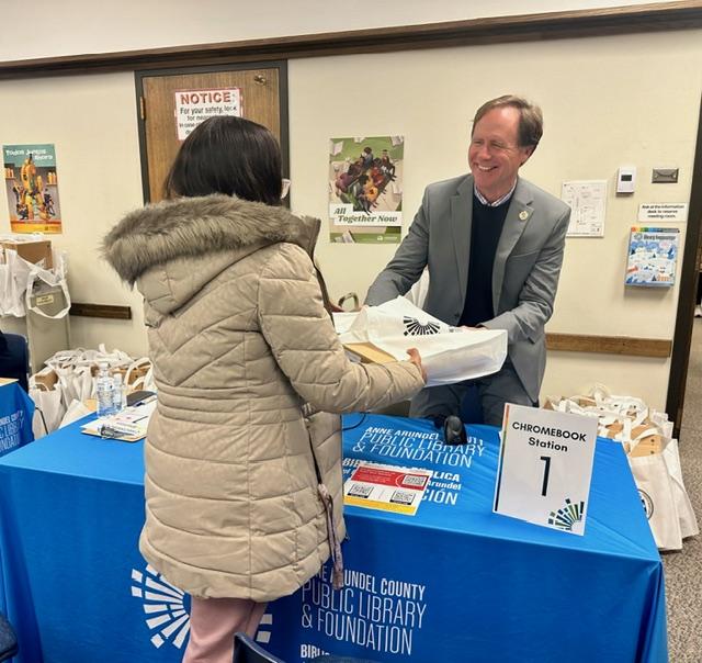 County Executive Pittman distributes a chromebook to an eligible resident. 