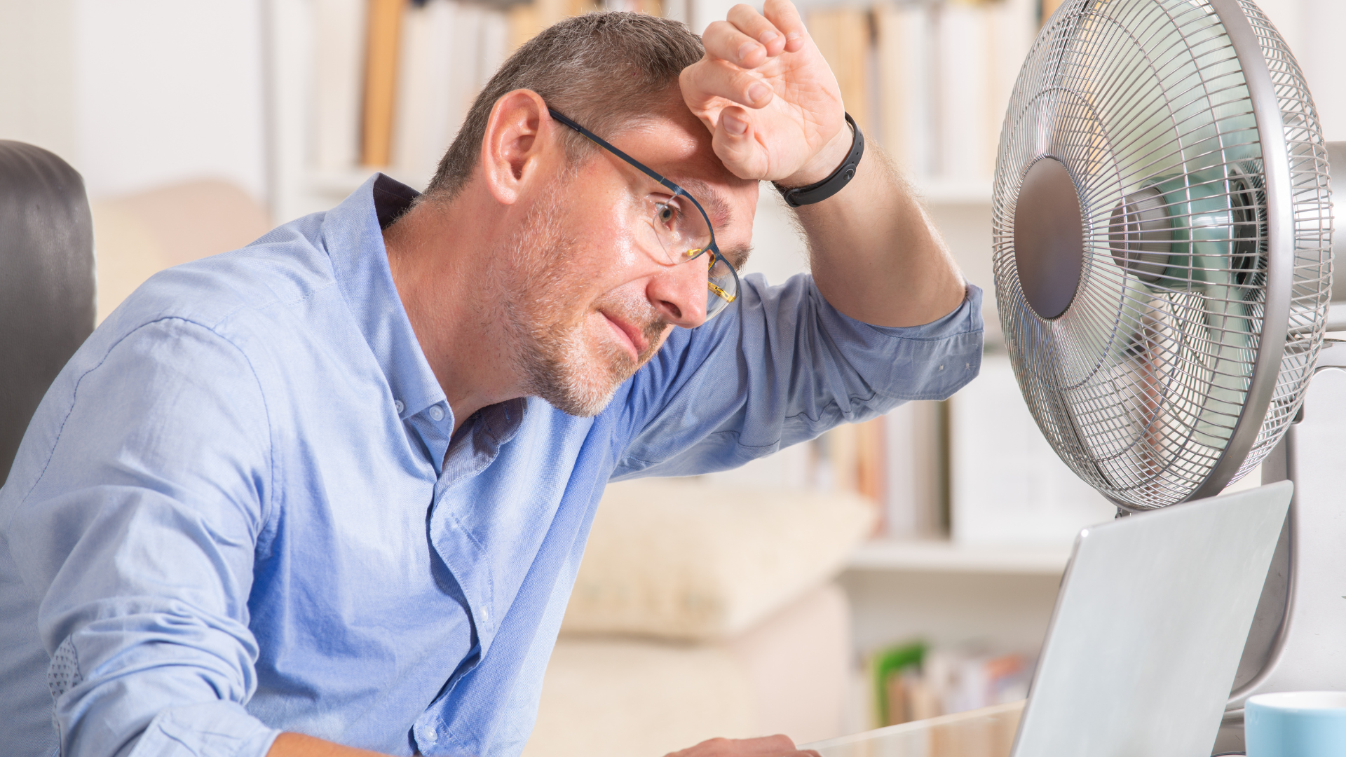 Man sitting in front of a fan