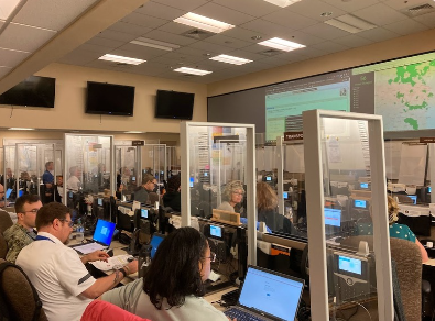 Large room filed with people working on computers