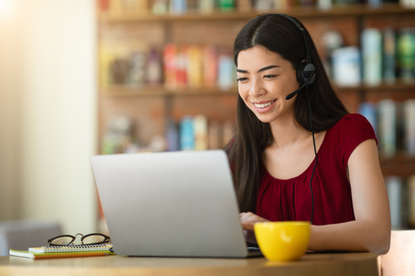 Female Headset Smiling at Laptop